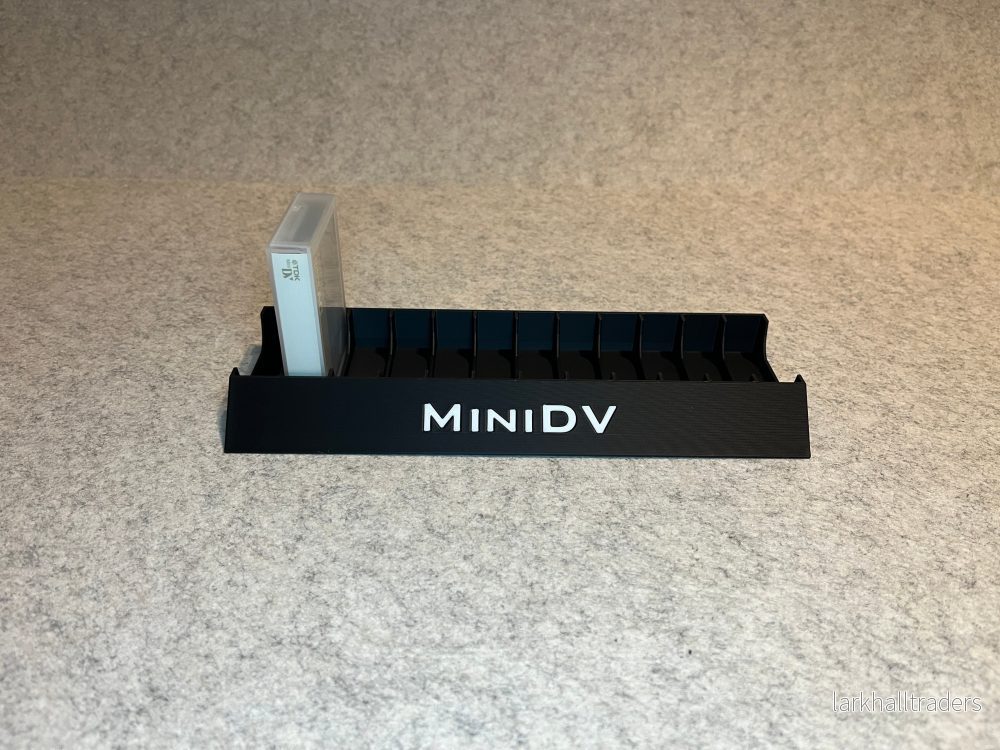 Skrivbordställ för 12 MiniDV-kassettband med MiniDV-text Skrivbordställ för 12 MiniDV-kassettband med MiniDV-text